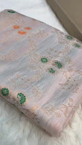 Ivory Banarasi Handloom Pure Katan Silk Saree with delicate floral vine zari pattern and green and orange Meenakari floral accents.