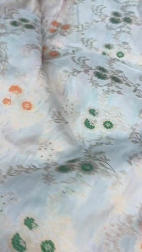 Ivory Banarasi Handloom Pure Katan Silk Saree with delicate floral vine zari pattern and green and orange Meenakari floral accents.