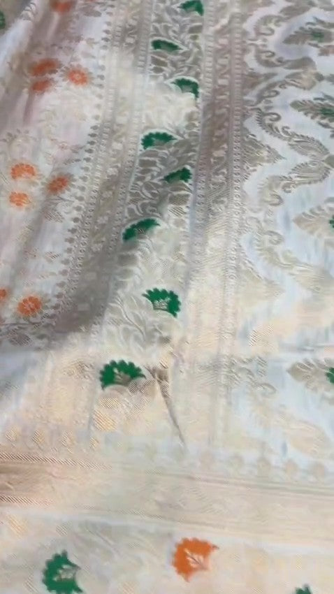 Ivory Banarasi Handloom Pure Katan Silk Saree with delicate floral vine zari pattern and green and orange Meenakari floral accents.