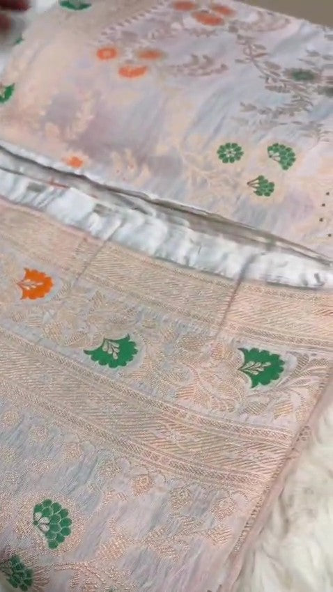 Ivory Banarasi Handloom Pure Katan Silk Saree with delicate floral vine zari pattern and green and orange Meenakari floral accents.