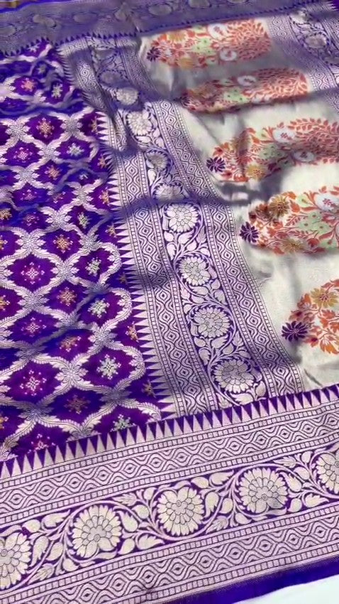 A deep royal purple Banarasi handloom pure Katan silk saree featuring vibrant multicolored Meenakari floral motifs and an elaborate silver zari border and pallu.
