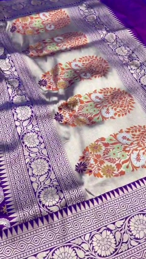 A deep royal purple Banarasi handloom pure Katan silk saree featuring vibrant multicolored Meenakari floral motifs and an elaborate silver zari border and pallu.