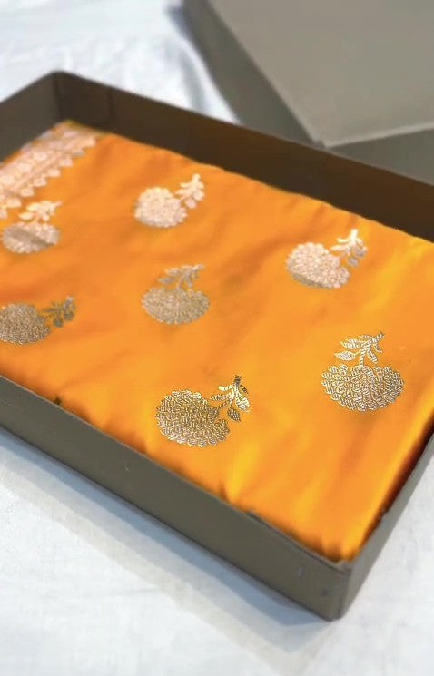Radiant golden yellow Banarasi Mashru soft silk saree featuring intricate silver and gold zari work, a heavy floral border, and classic woven buttis.