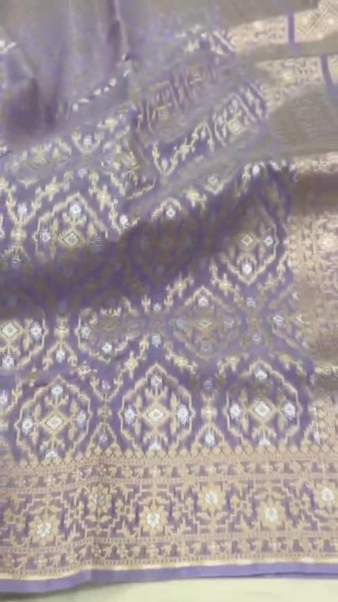  lavender Banarasi mercerised cotton saree with intricate gold and silver Sona Rupa zari weaving, posed beautifully in an elegant setting.