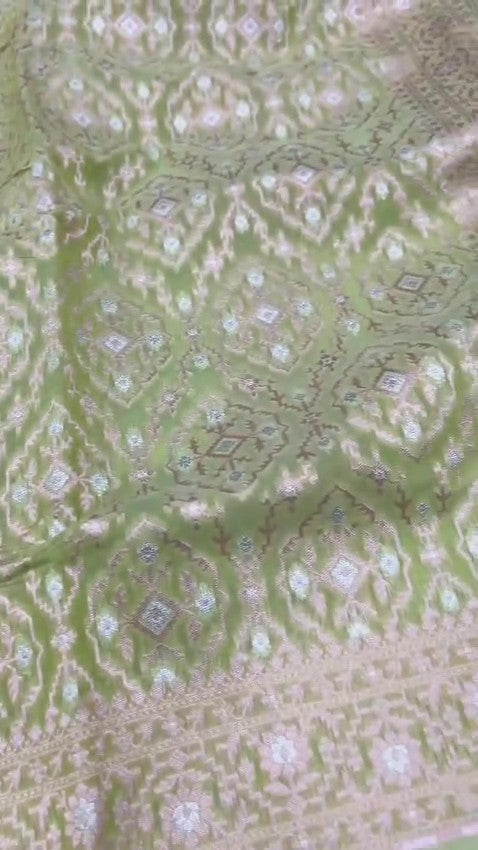 Pastel green Banarasi mercerised cotton saree featuring gold and silver Sona Rupa zari weaving, set against a luxury boutique backdrop.