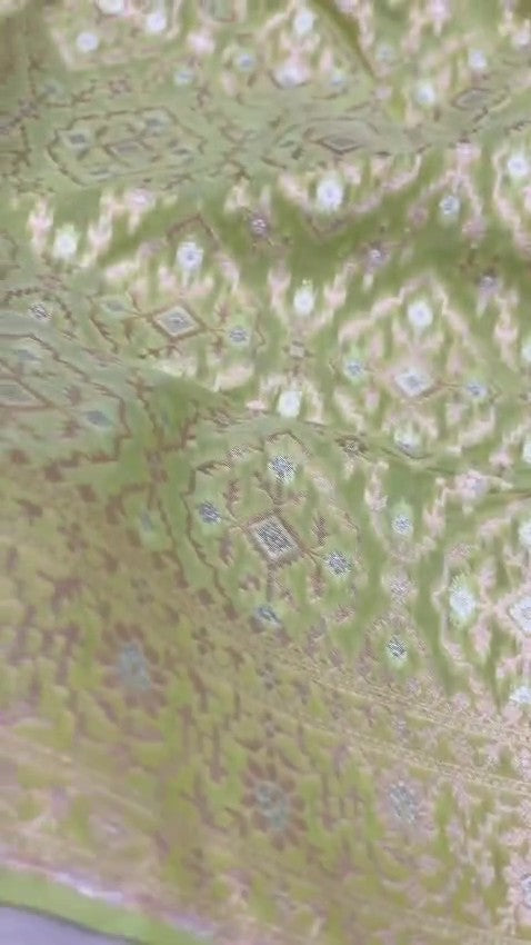 Pastel green Banarasi mercerised cotton saree featuring gold and silver Sona Rupa zari weaving, set against a luxury boutique backdrop.