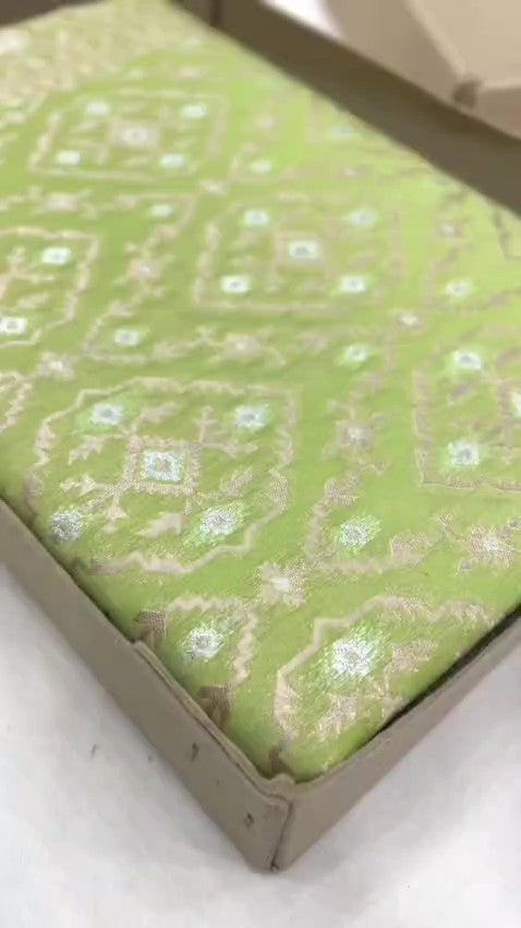 Pastel green Banarasi mercerised cotton saree featuring gold and silver Sona Rupa zari weaving, set against a luxury boutique backdrop.