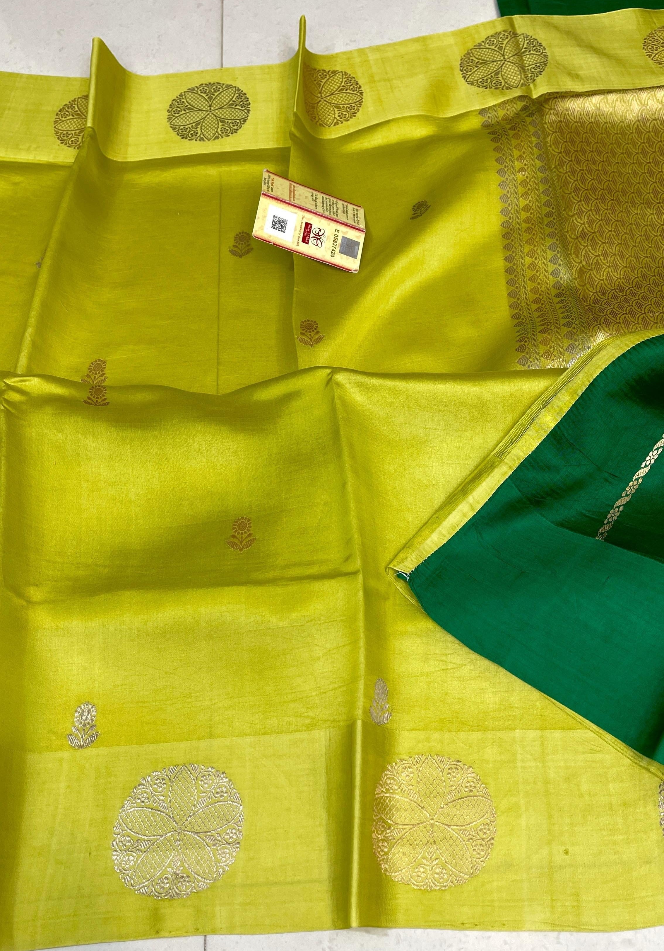 Lime Green Banarasi Raw Mango Silk saree featuring intricate gold zari floral butis and a wide gold Mashru border, paired with a contrast emerald green blouse.
