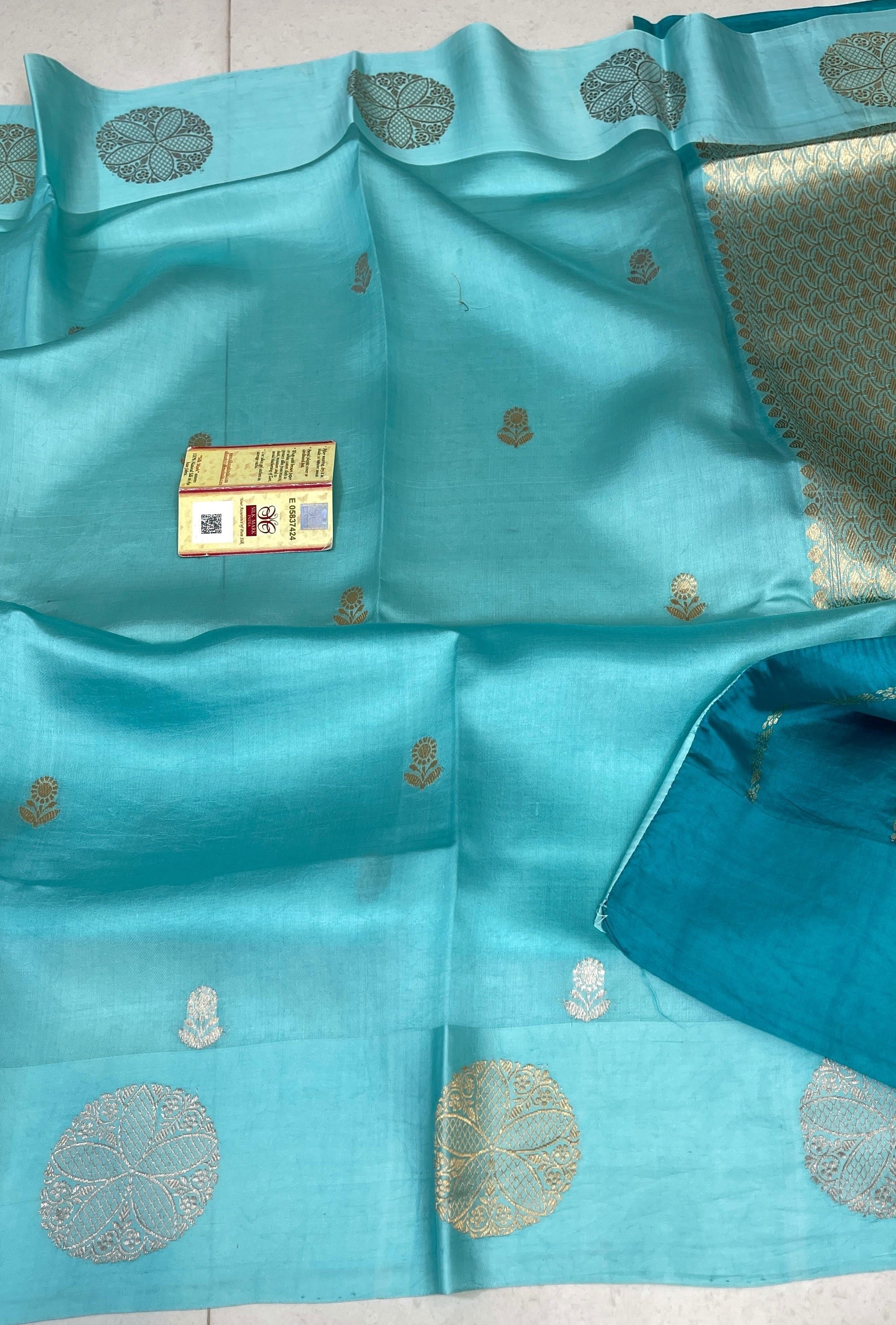 Luminous Turquoise Banarasi Raw Mango Silk saree with intricate gold zari work and a traditional Mashru border, paired with an elegant blouse.