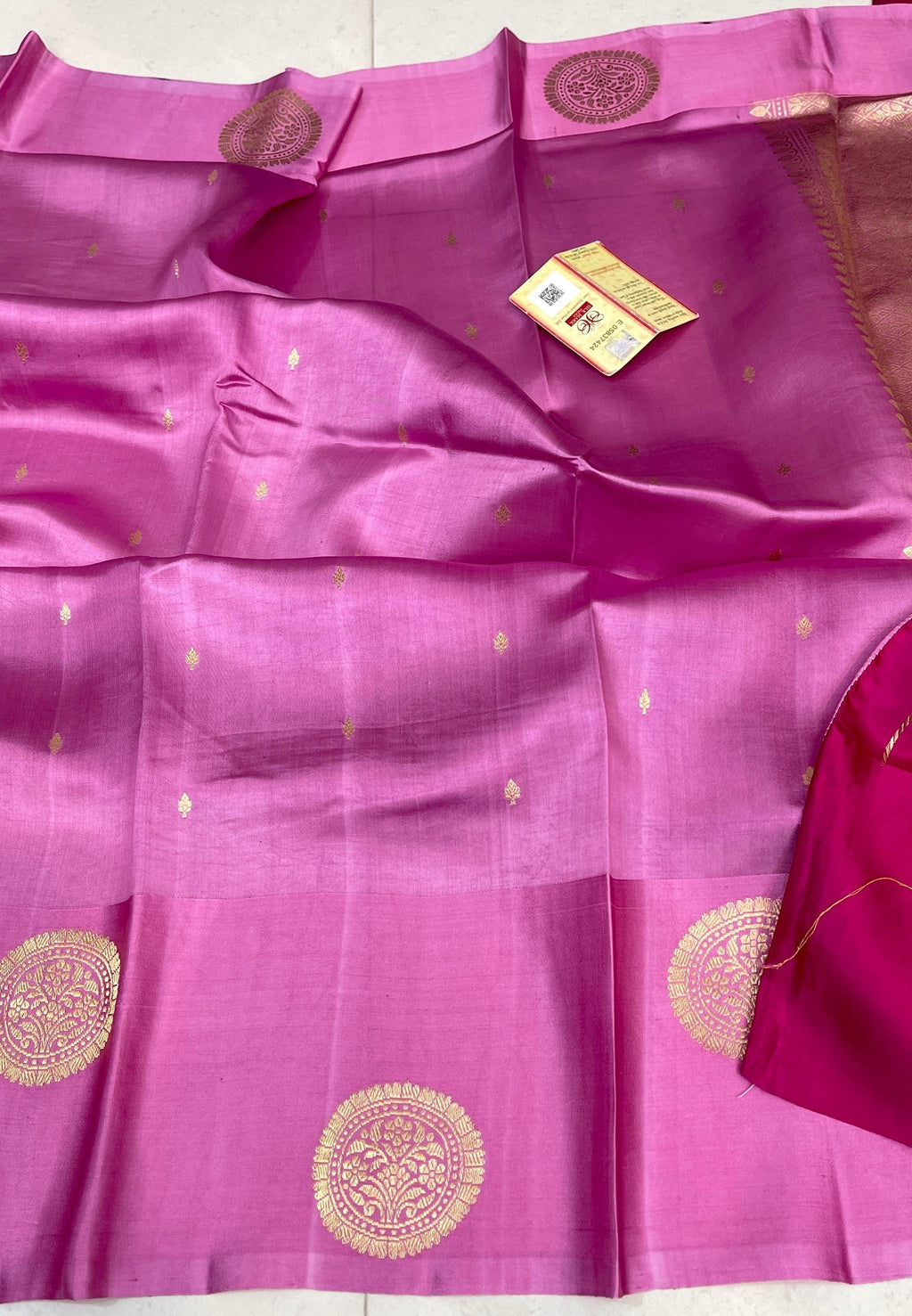Vibrant Hot Pink Banarasi Raw Mango Silk saree with intricate gold zari floral motifs and a luxurious gold Mashru border, paired with a matching blouse.