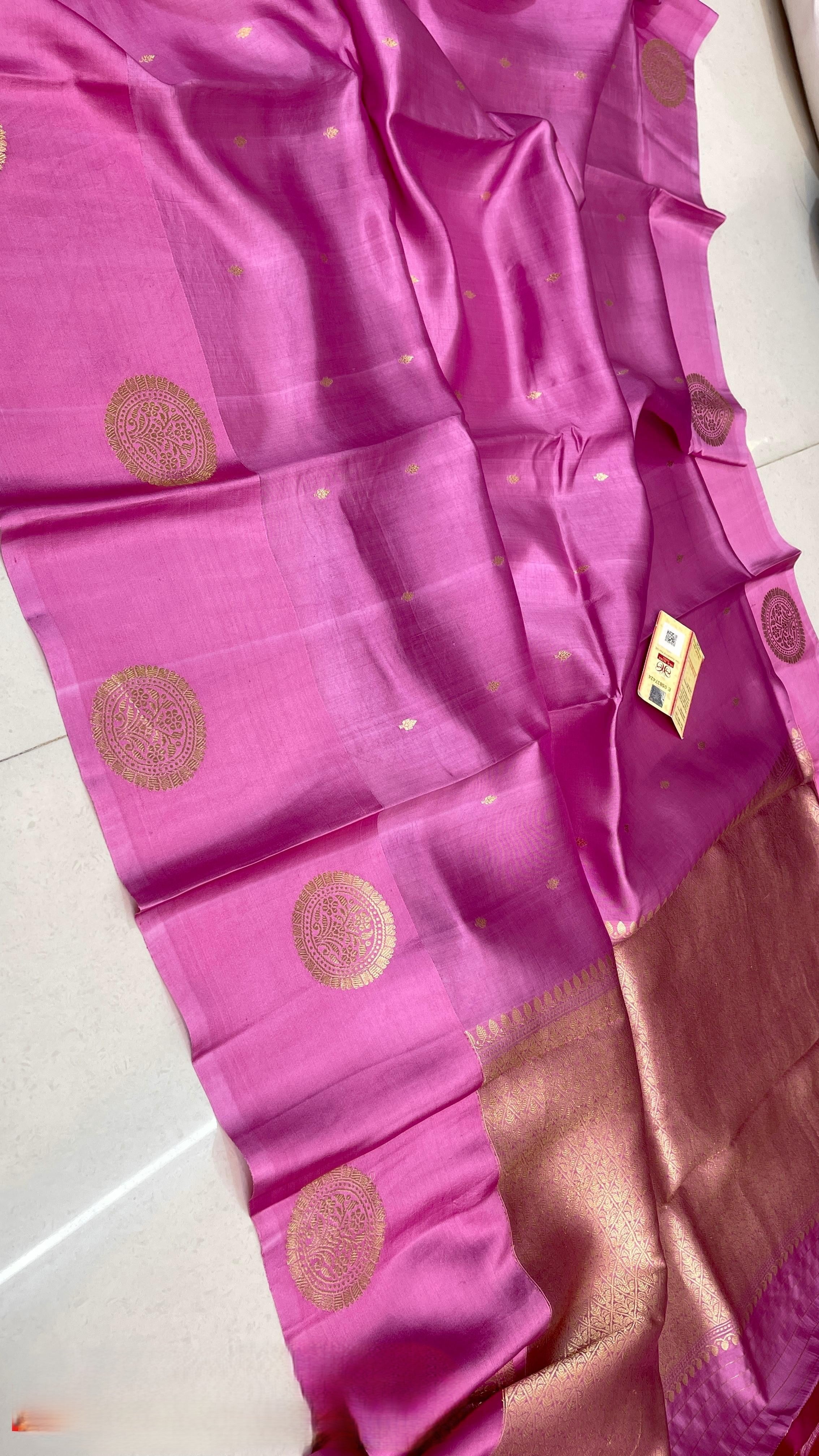 Vibrant Hot Pink Banarasi Raw Mango Silk saree with intricate gold zari floral motifs and a luxurious gold Mashru border, paired with a matching blouse.