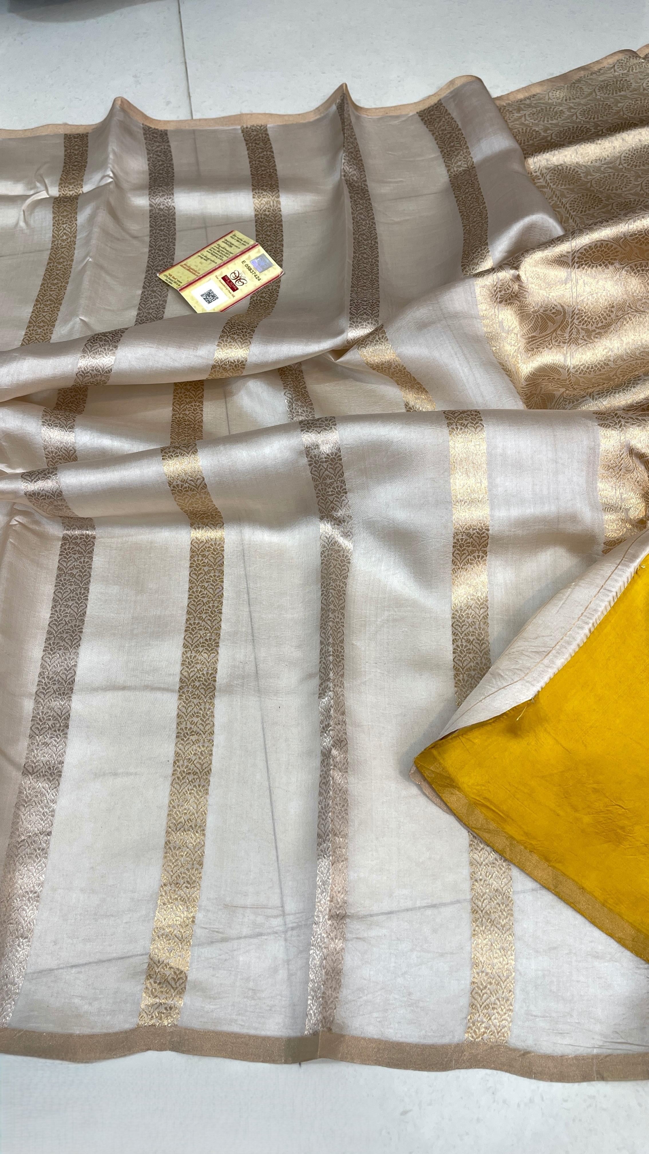 Ivory Banarasi Raw Mango Silk saree with horizontal Gold and Silver zari stripes, Kaduwa weaving, and a mustard yellow blouse.