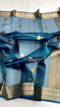 Peacock blue Banarasi handloom kora tissue silk saree featuring shimmering zari weaving, intricate borders, and a certified authentic finish.