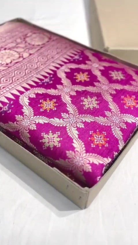 A stunning pink Banarasi handloom pure Katan silk saree adorned with multicolored Meenakari floral patterns and a rich silver zari border, perfect for weddings.