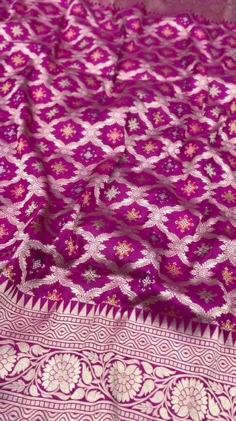 A stunning pink Banarasi handloom pure Katan silk saree adorned with multicolored Meenakari floral patterns and a rich silver zari border, perfect for weddings.