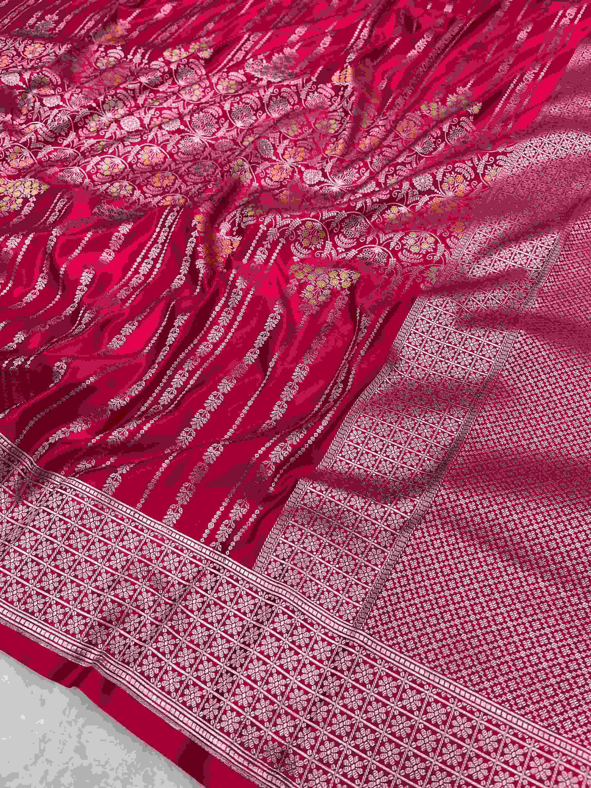 Rani Pink Banarasi mashru soft silk saree woven with intricate golden zari floral jangla jaal, vertical pinstripes, meenakari accents, and geometric borders.