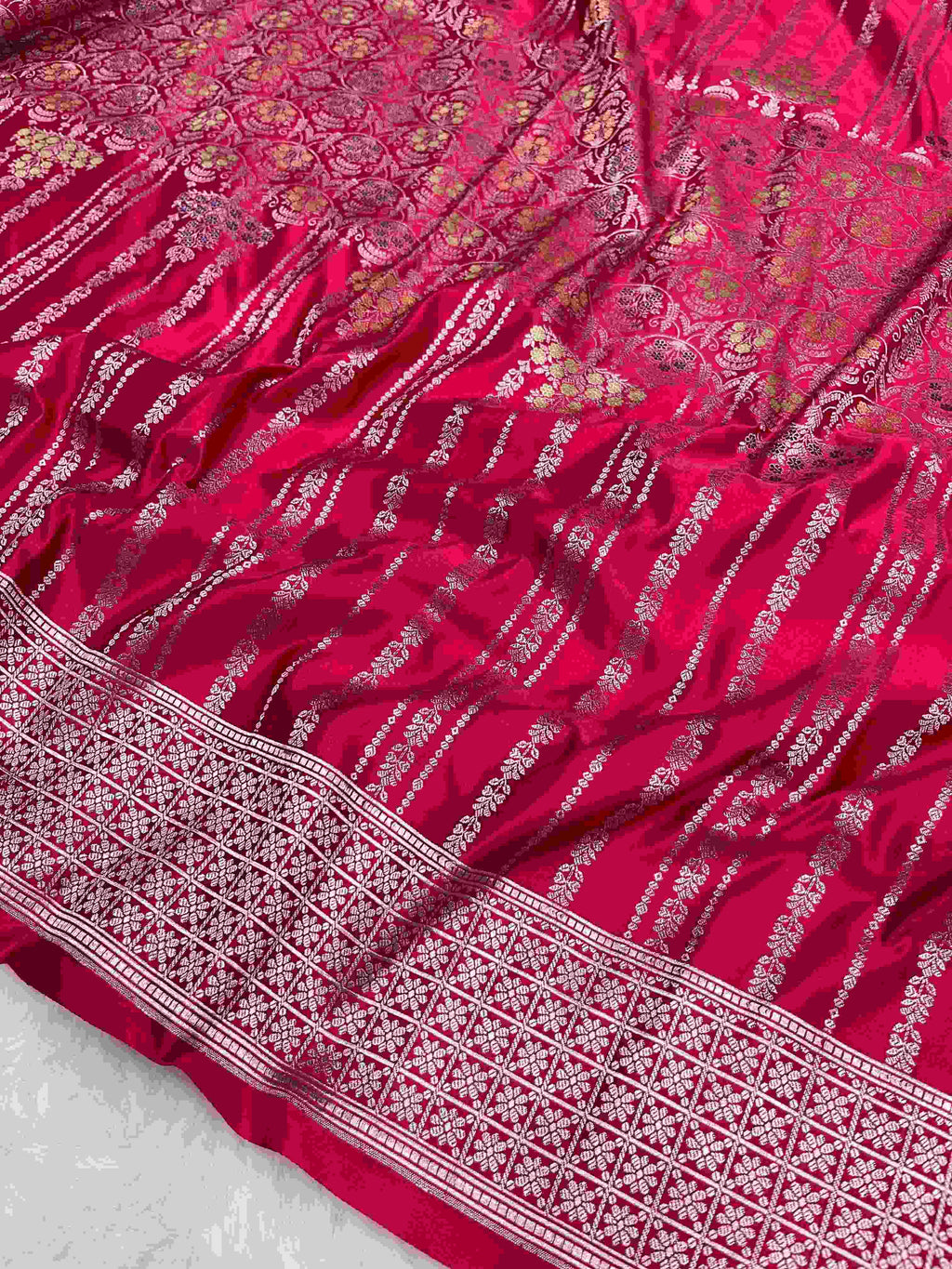Rani Pink Banarasi mashru soft silk saree woven with intricate golden zari floral jangla jaal, vertical pinstripes, meenakari accents, and geometric borders.