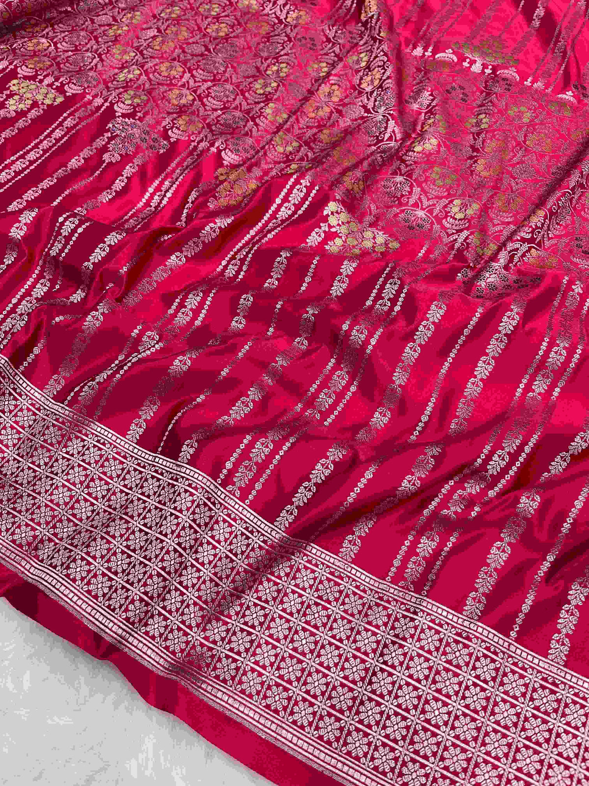 Rani Pink Banarasi mashru soft silk saree woven with intricate golden zari floral jangla jaal, vertical pinstripes, meenakari accents, and geometric borders.