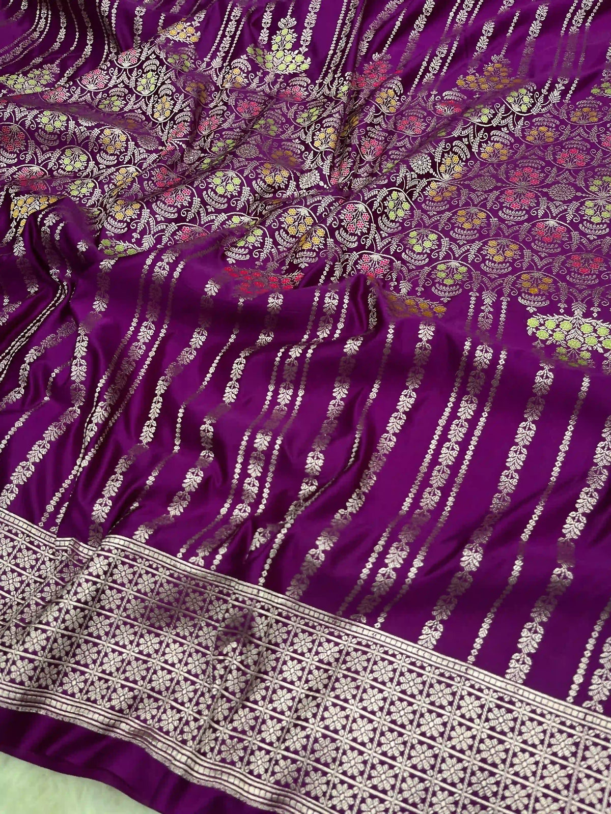 Purple Banarasi mashru soft silk saree featuring intricate golden zari floral jangla weaving, vertical pinstripes, meenakari highlights, and a ornate zari border.