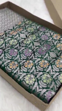 Bottle green Banarasi mashru soft silk saree featuring all-over golden zari floral jangla weaving, delicate meenakari highlights, and intricate zari borders.