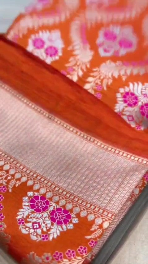 Orange Banarasi handloom pure chiniya silk saree featuring intricate silver sona roopa meenakari patterns.