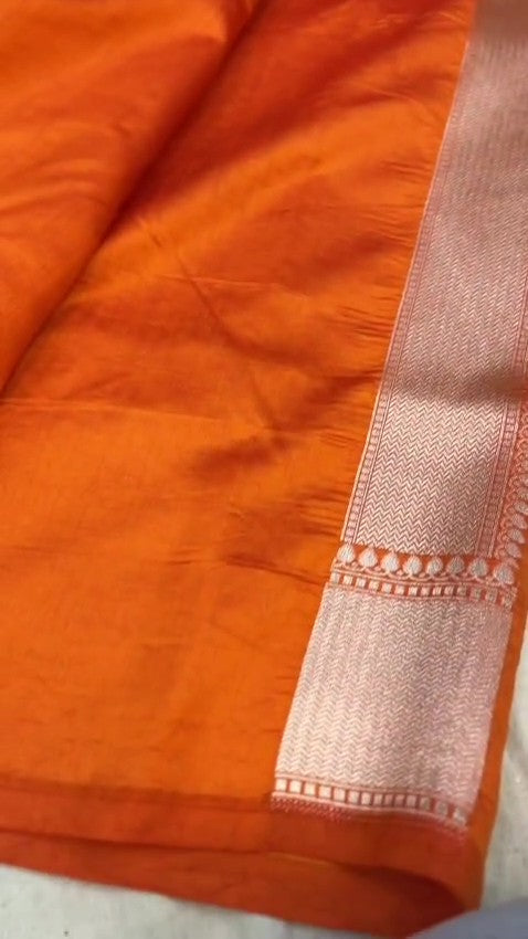Orange Banarasi handloom pure chiniya silk saree featuring intricate silver sona roopa meenakari patterns.