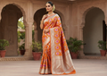 A model showcasing a vibrant orange Banarasi handloom pure chiniya silk saree featuring intricate silver sona roopa meenakari patterns.