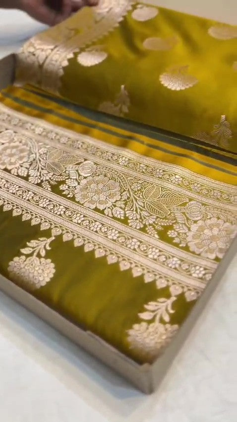 Olive Mustard Banarasi Mashru soft silk saree featuring intricate copper zari floral butas and an ornate traditional silver zari border.