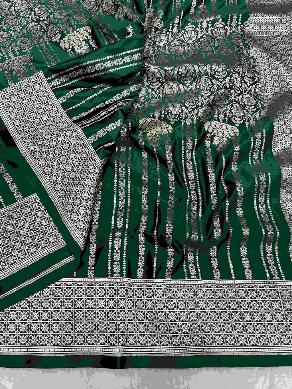 Bottle green Banarasi mashru soft silk saree featuring all-over golden zari floral jangla weaving, delicate meenakari highlights, and intricate zari borders.