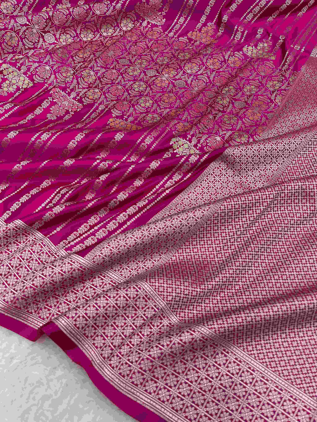 Hot pink Banarasi mashru soft silk saree detailed with all-over golden zari floral jangla weaving, meenakari highlights, and intricate zari borders.