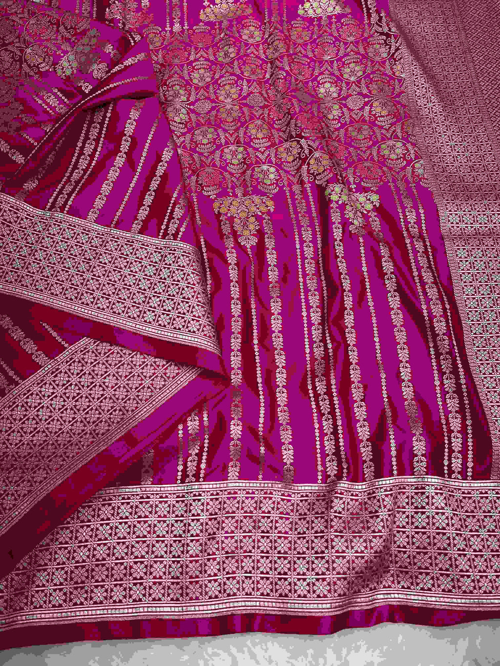 Hot pink Banarasi mashru soft silk saree detailed with all-over golden zari floral jangla weaving, meenakari highlights, and intricate zari borders.