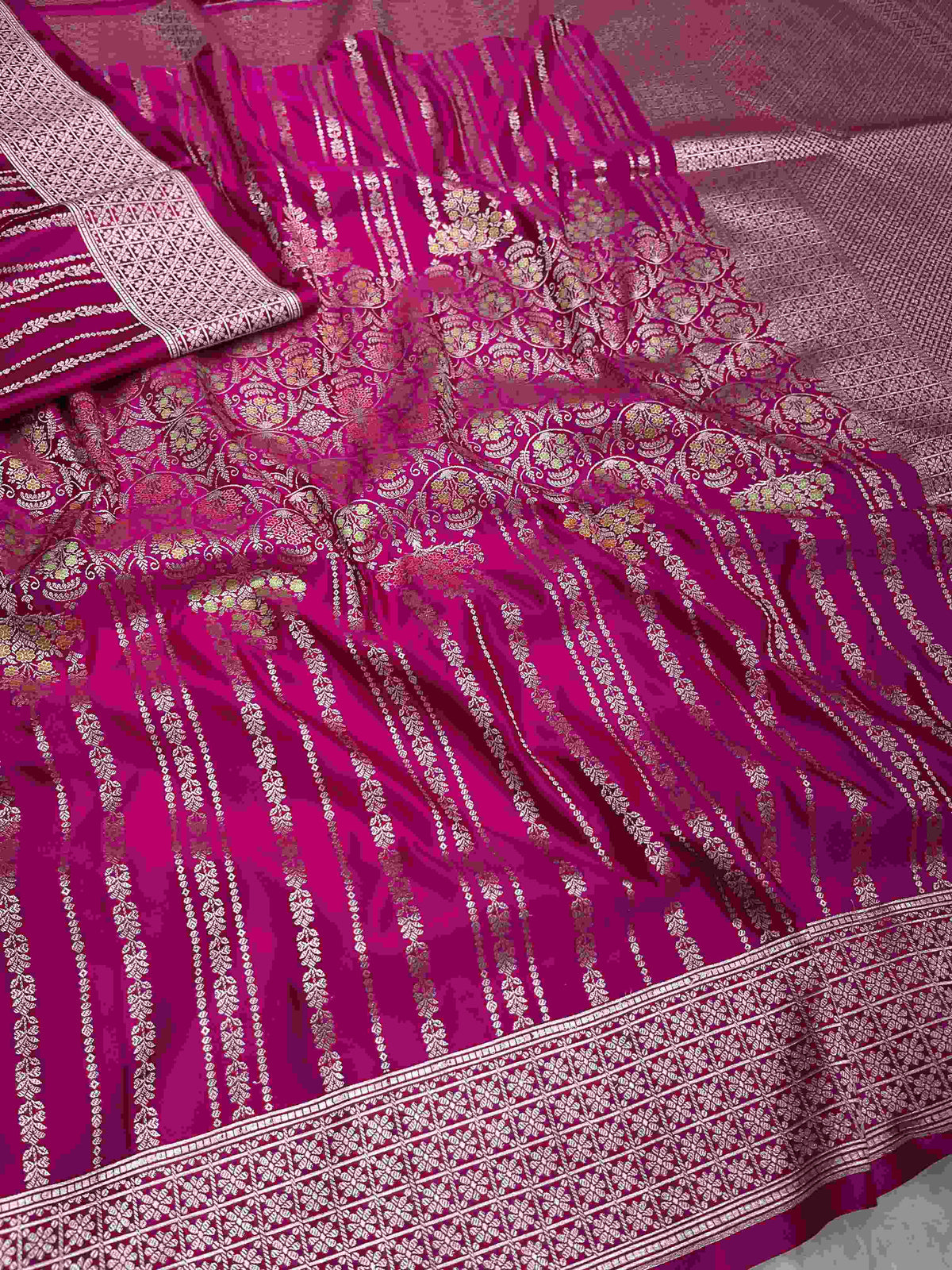 Hot pink Banarasi mashru soft silk saree detailed with all-over golden zari floral jangla weaving, meenakari highlights, and intricate zari borders.
