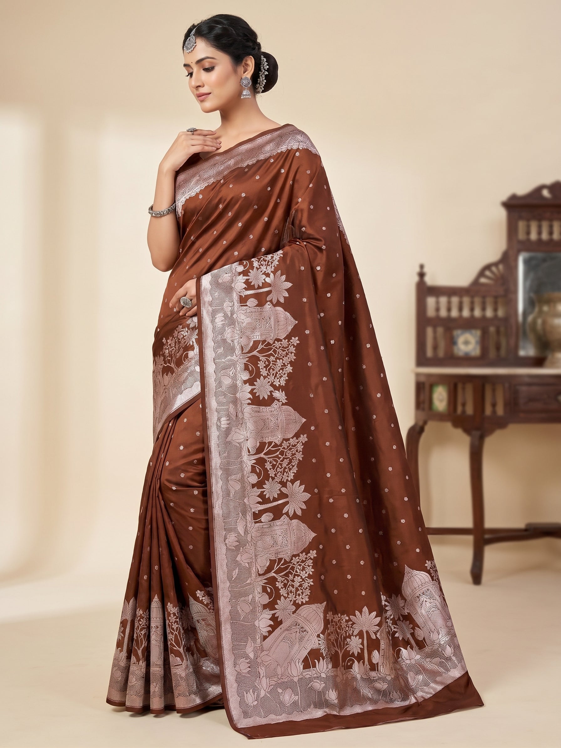 Model wearing a brown Banarasi Mashru soft silk saree detailed with intricate silver zari architectural and floral motifs