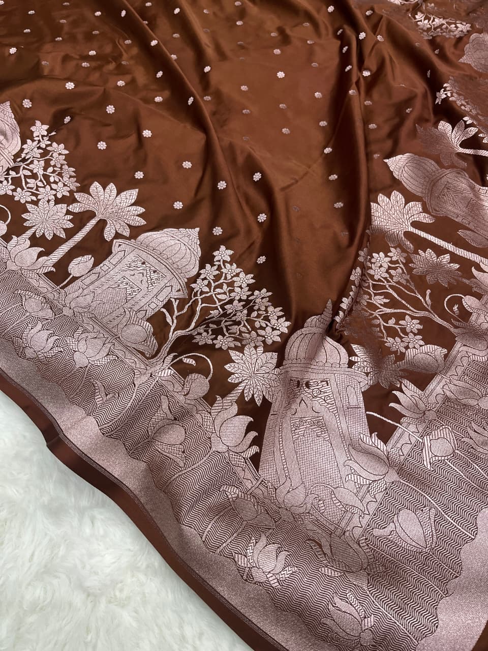 Model wearing a brown Banarasi Mashru soft silk saree detailed with intricate silver zari architectural and floral motifs