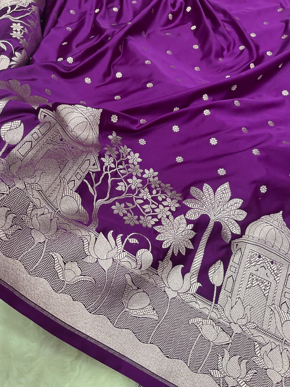 Elegant purple Banarasi Mashru soft silk saree detailed with shimmering silver zari woven borders and pallu.