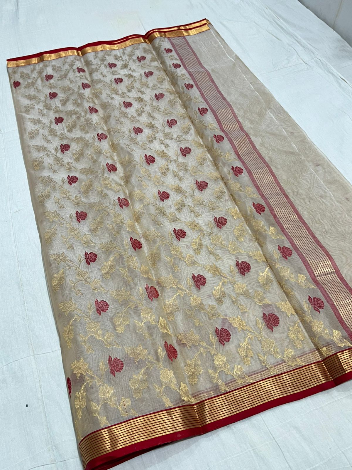 Ivory Chanderi handloom Katan silk saree with intricate red floral meenakari motifs and a gold zari border by Silk Tatva.