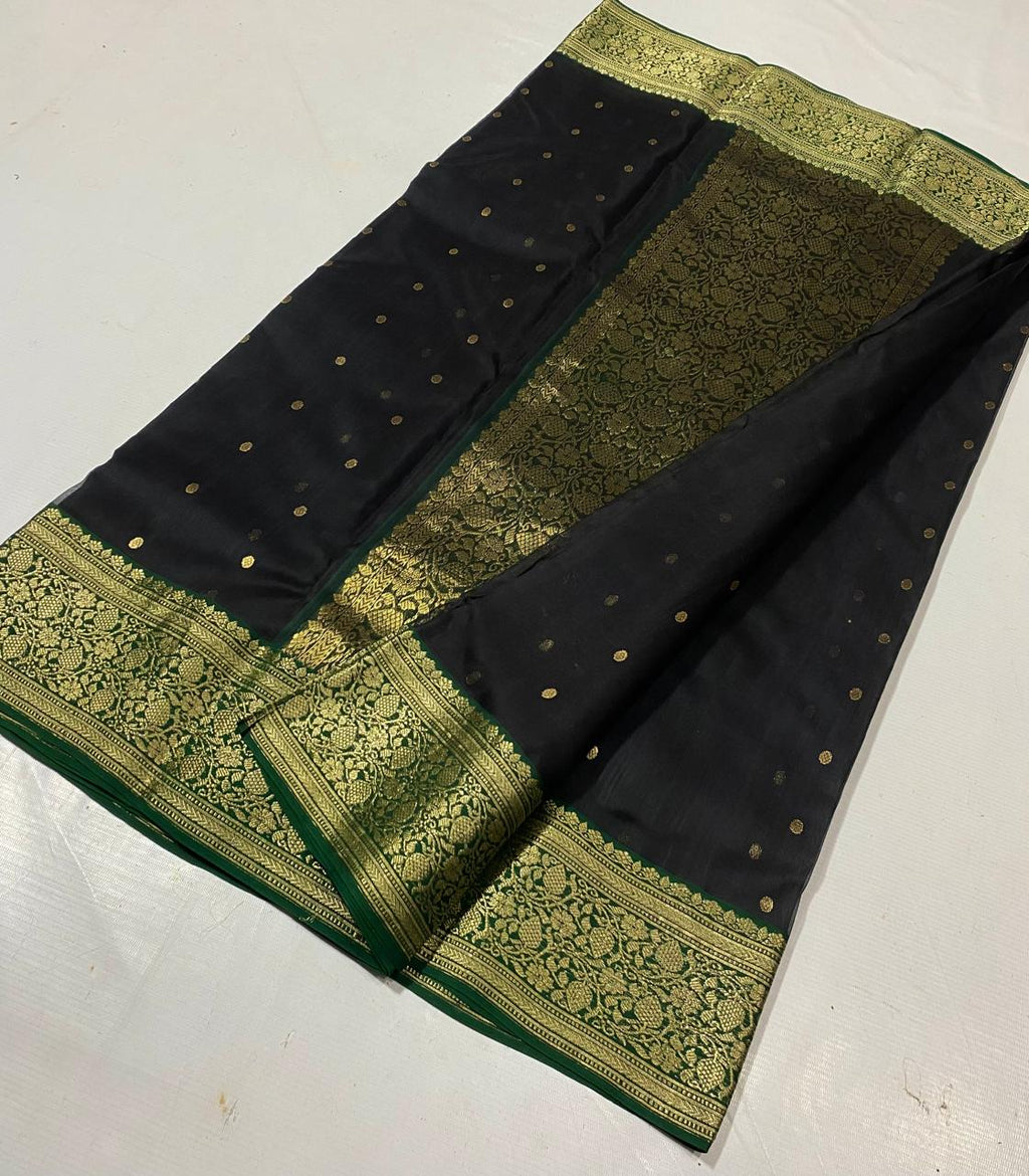 Black Chanderi handloom katan silk saree featuring intricate green and gold woven borders with small gold motifs.