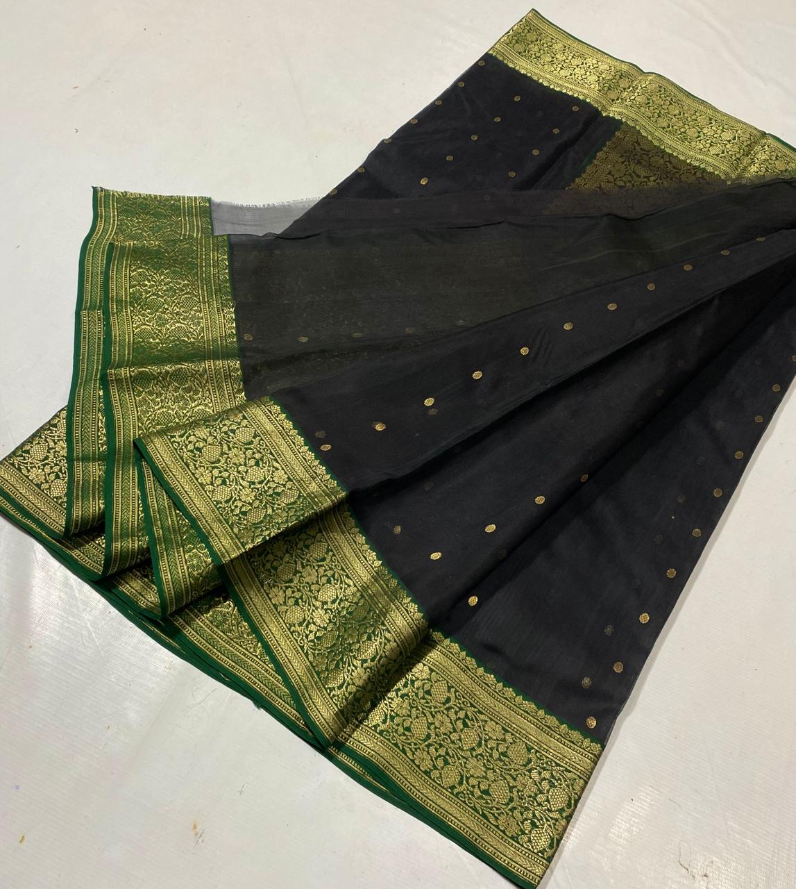 Black Chanderi handloom katan silk saree featuring intricate green and gold woven borders with small gold motifs.