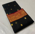 Black Chanderi handloom katan silk saree featuring intricate green and gold woven borders with small gold motifs.