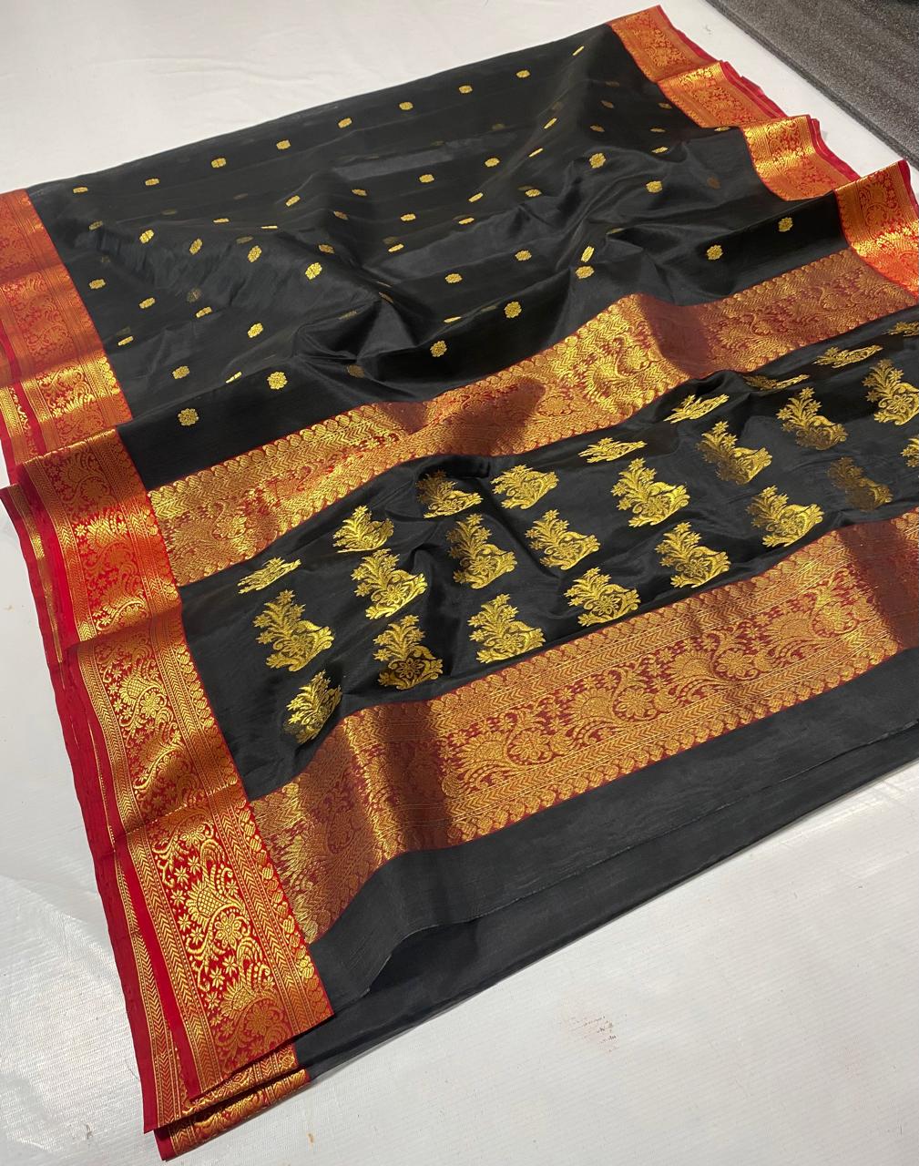 Black Chanderi handloom katan silk saree featuring intricate green and gold woven borders with small gold motifs.