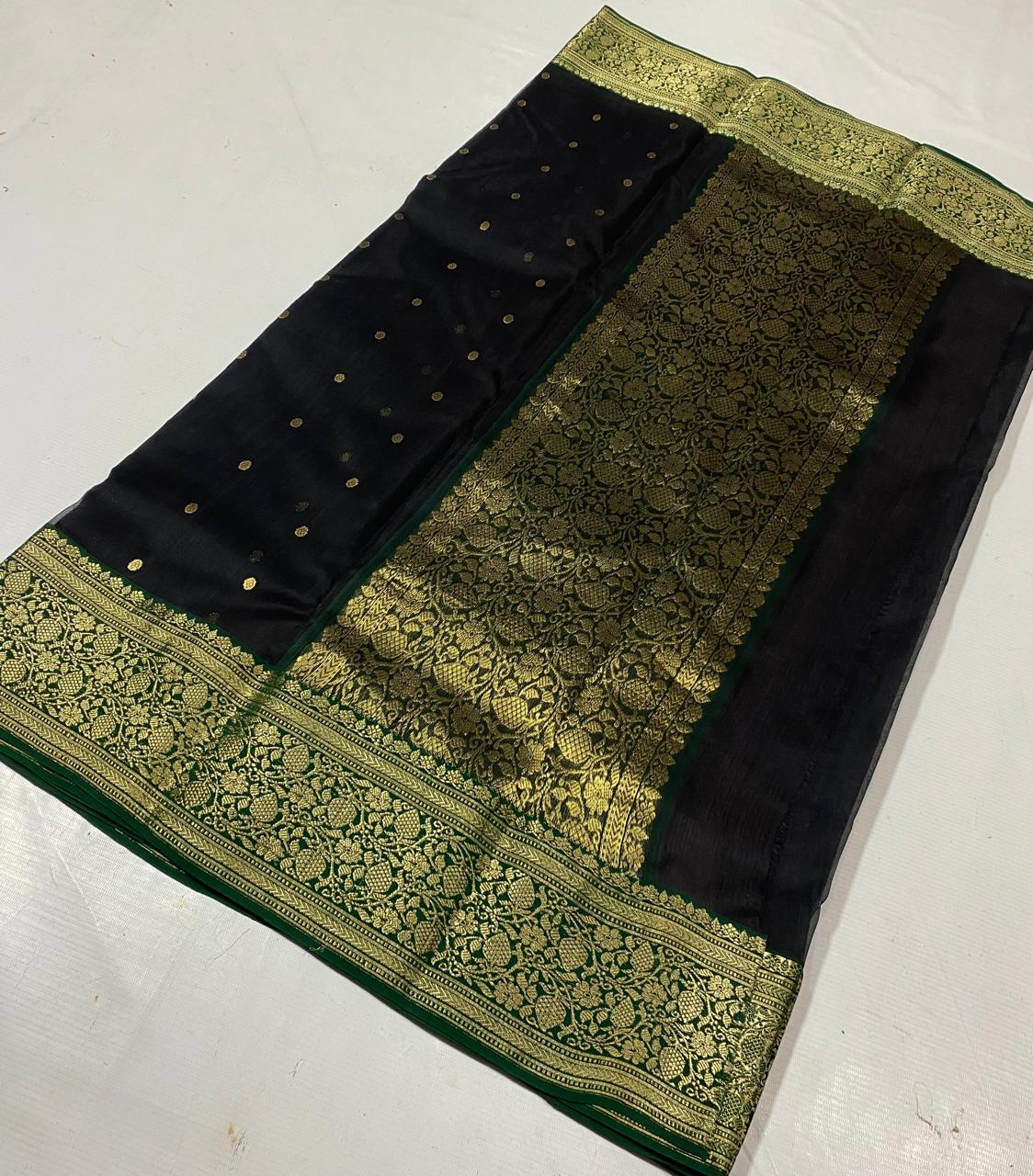 Black Chanderi handloom katan silk saree featuring intricate green and gold woven borders with small gold motifs.