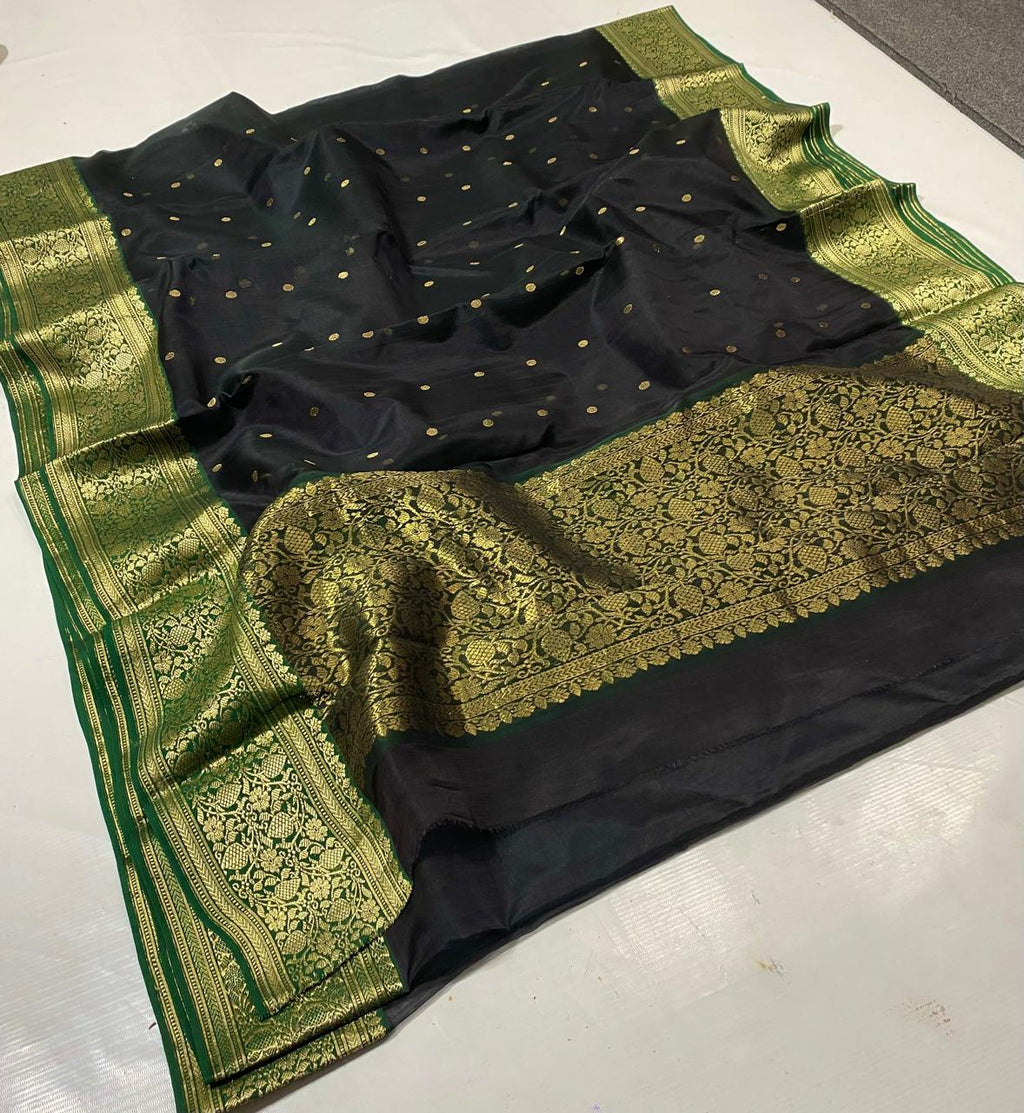 Black Chanderi handloom katan silk saree featuring intricate green and gold woven borders with small gold motifs.