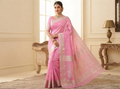 A model in a standing position wearing a pink Chanderi handloom katan silk saree featuring silver zari borders and leaf buttas.