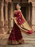 A model gracefully posing in a deep red Chanderi Handloom Pattu Silk saree with gold zari polka dot motifs and a rich golden border.