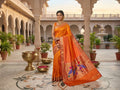 Coral Orange Paithani Handloom Pure Silk Saree featuring delicate self buttas on the body and a tissue zari pallu with colorful peacocks perched on flowering branches.