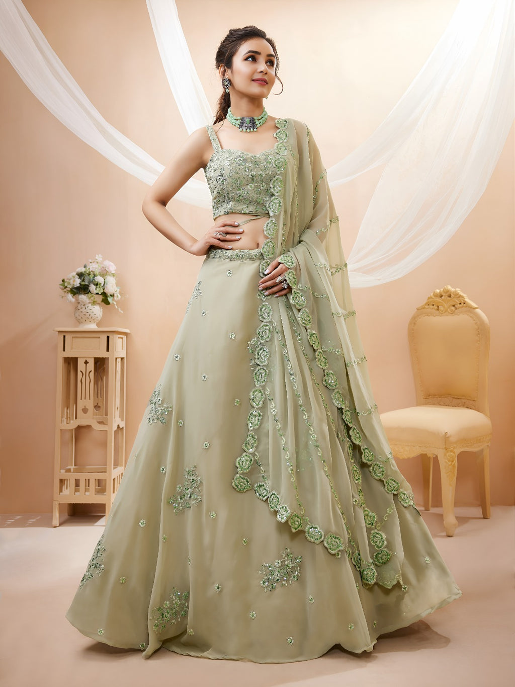 Model wearing a stunning pista green designer lehenga choli featuring intricate embroidery and a matching sheer dupatta