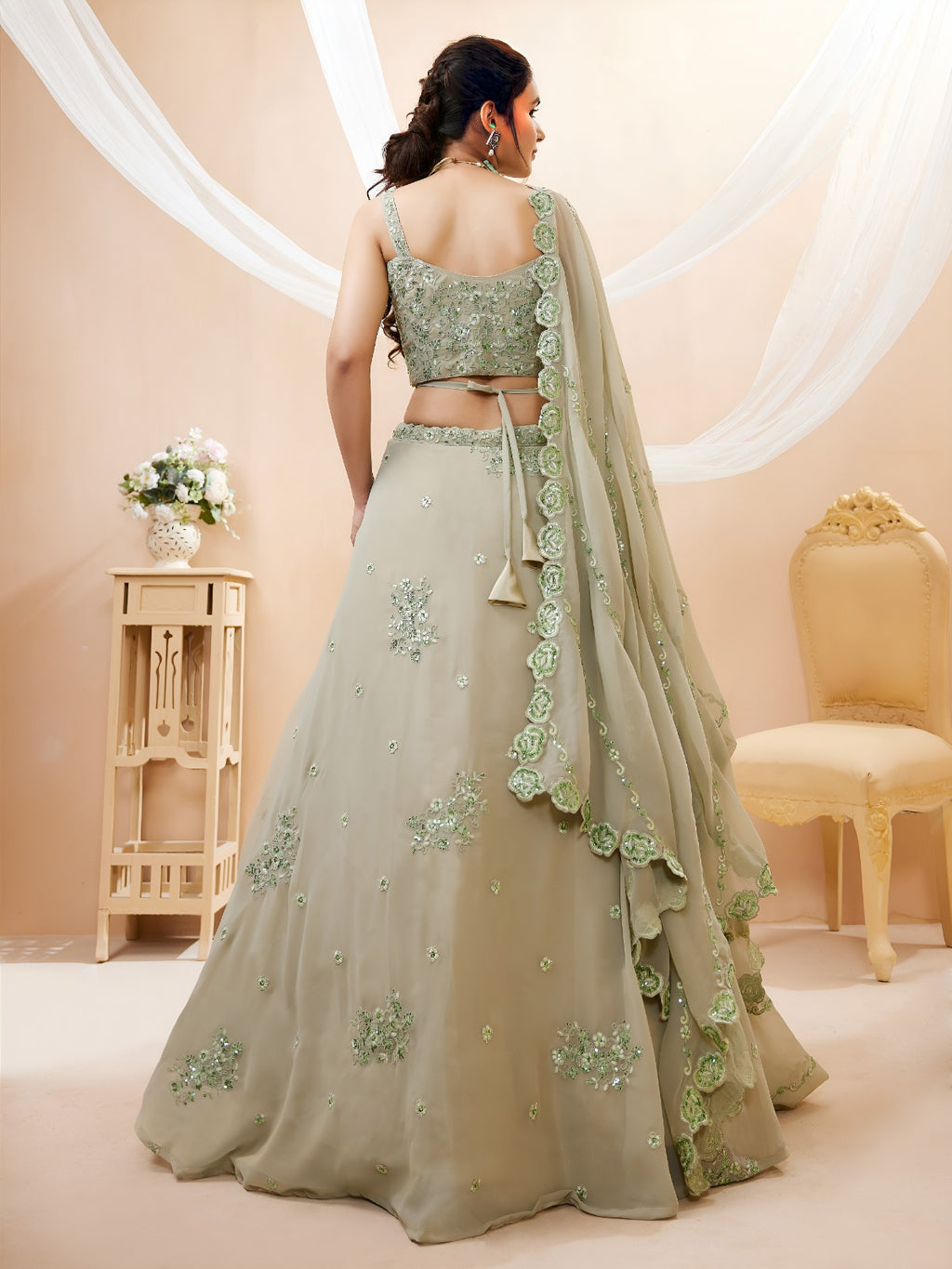 Model wearing a stunning pista green designer lehenga choli featuring intricate embroidery and a matching sheer dupatta