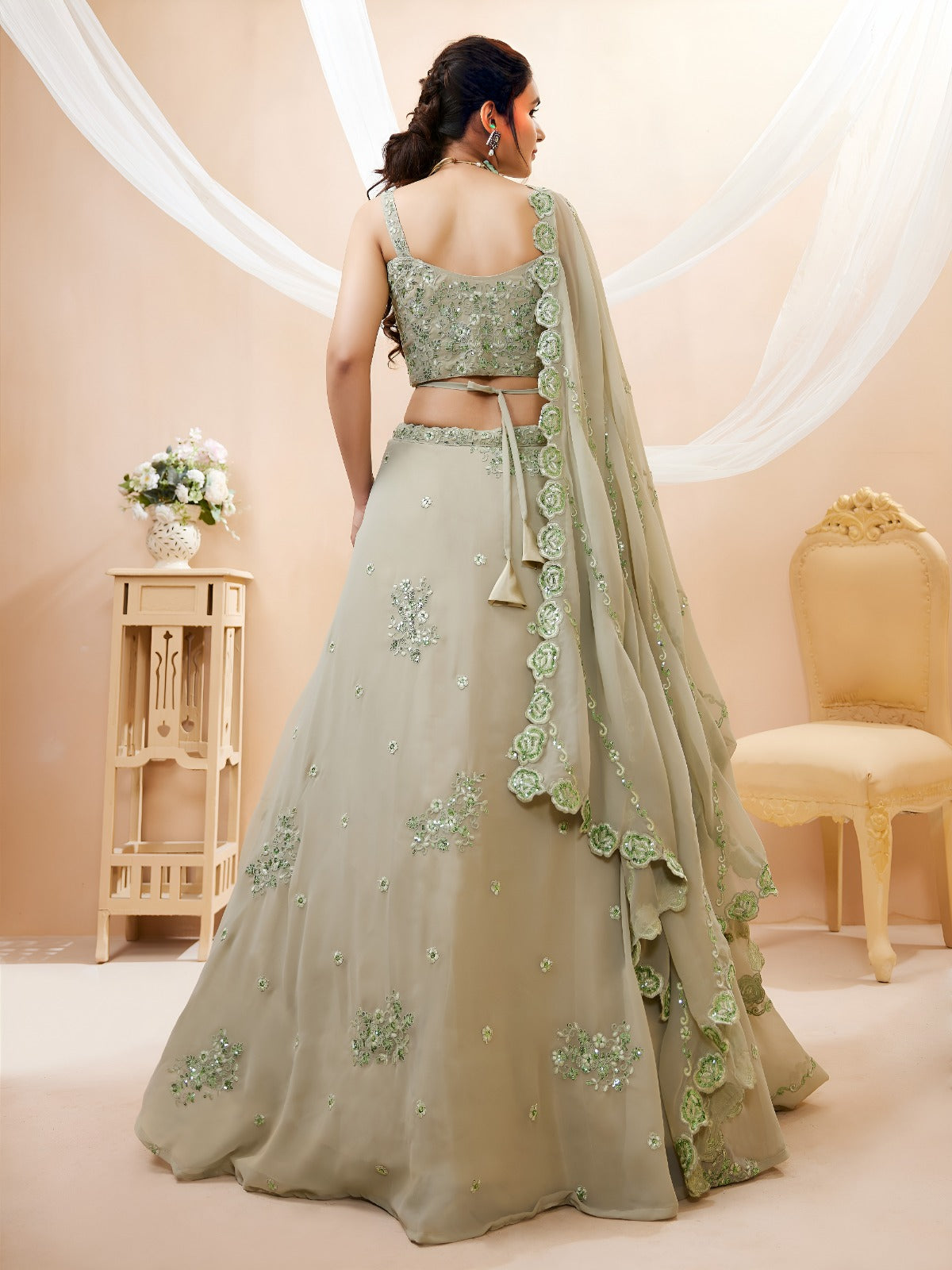 Model wearing a stunning pista green designer lehenga choli featuring intricate embroidery and a matching sheer dupatta