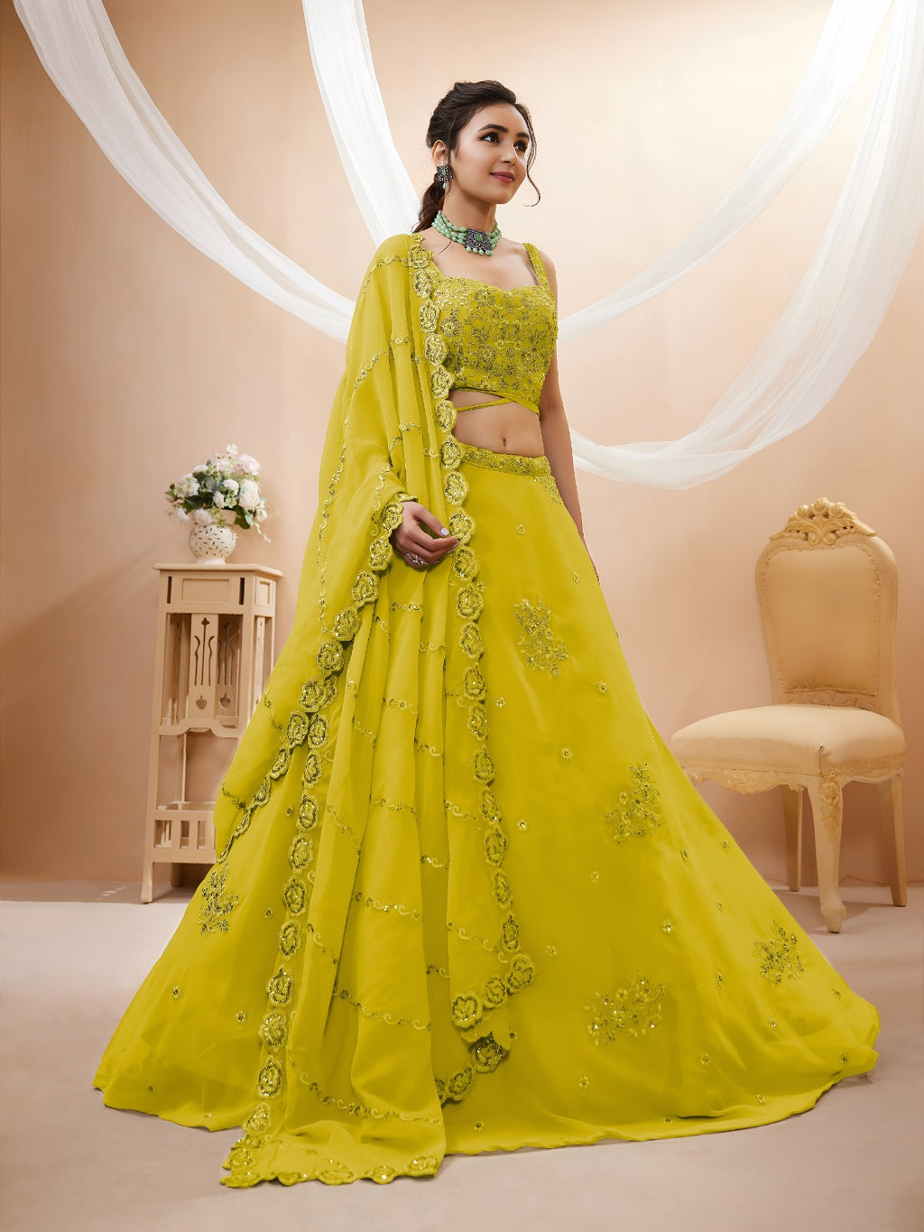 Model wearing a stunning lime green designer lehenga choli featuring intricate embroidery and a matching sheer dupatta