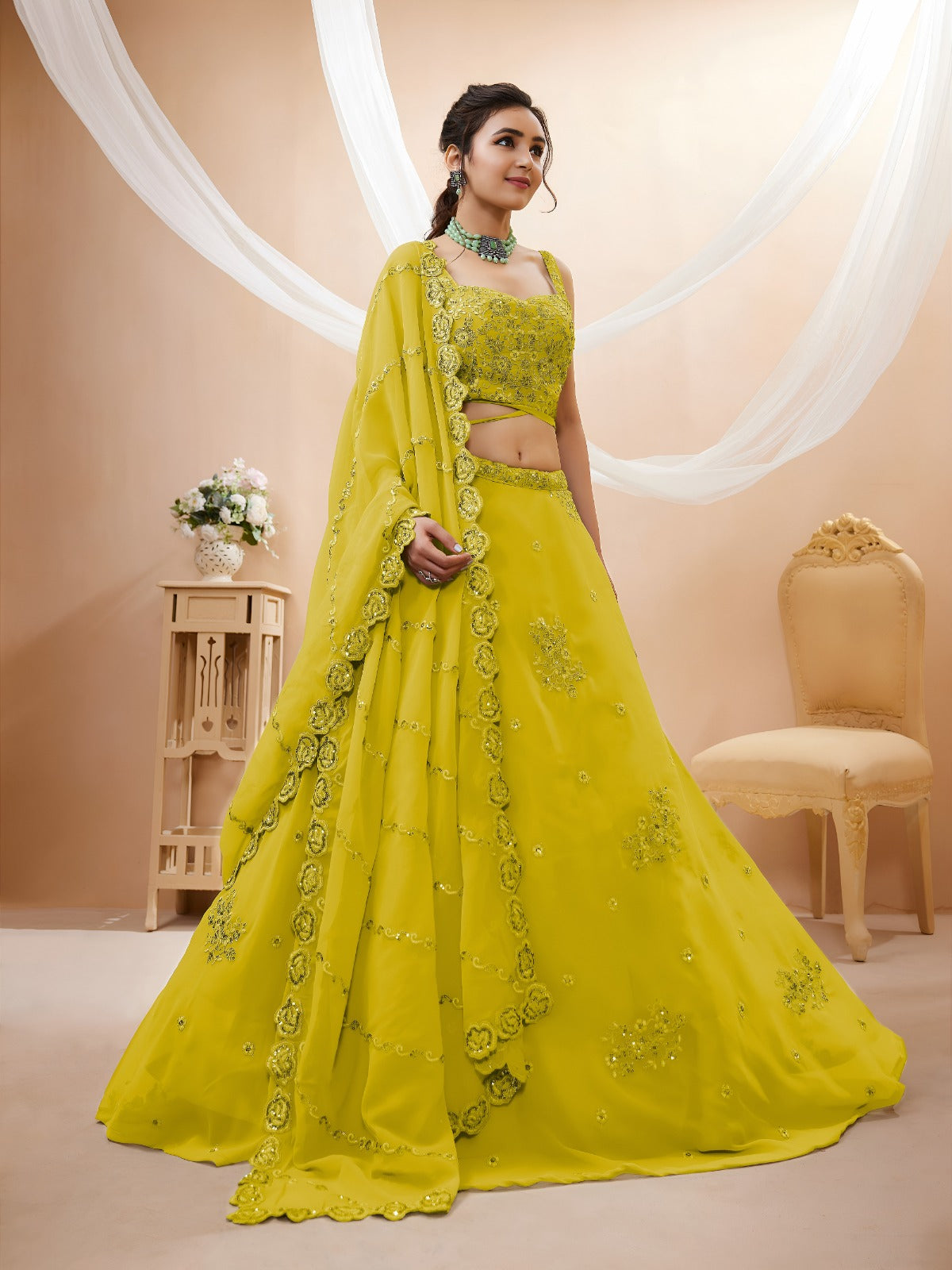 Model wearing a stunning lime green designer lehenga choli featuring intricate embroidery and a matching sheer dupatta